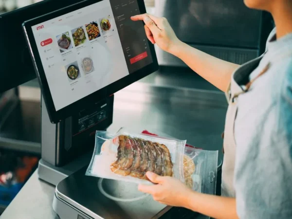 Person using digital POS system in a restaurant for cashless food payment.