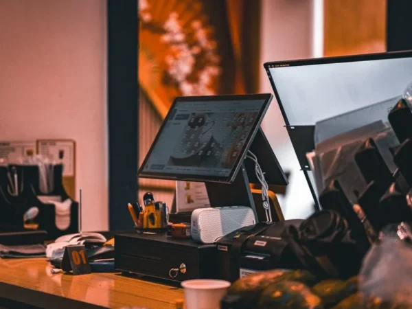 Counter with cash register and computer screen in Ho Chi Minh City cafe, offering a modern and warm ambiance.